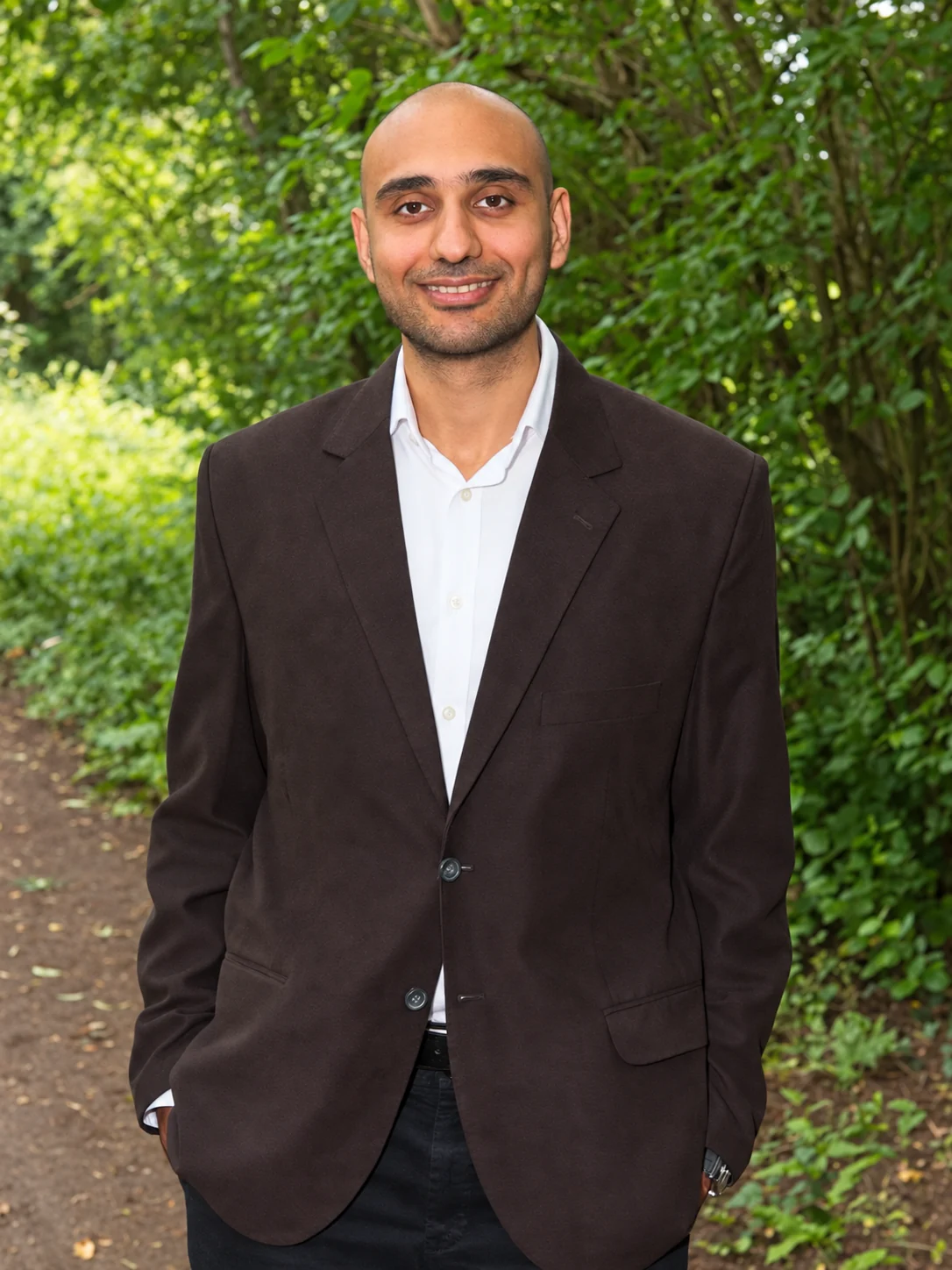 Adel Moin, hypnotherapist in Rugby, standing on a woodland path