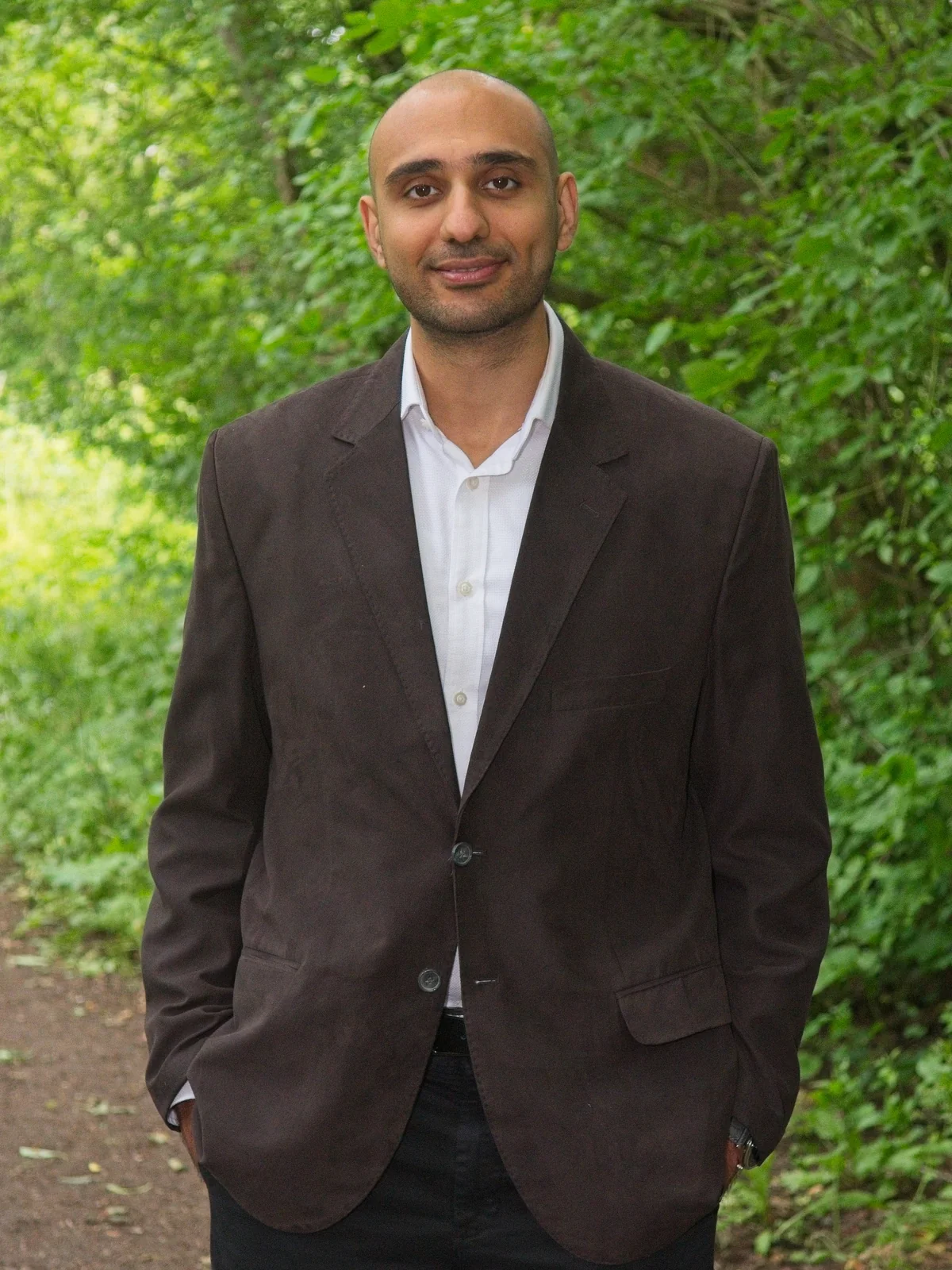 Adel Moin standing on a leafy woodland path