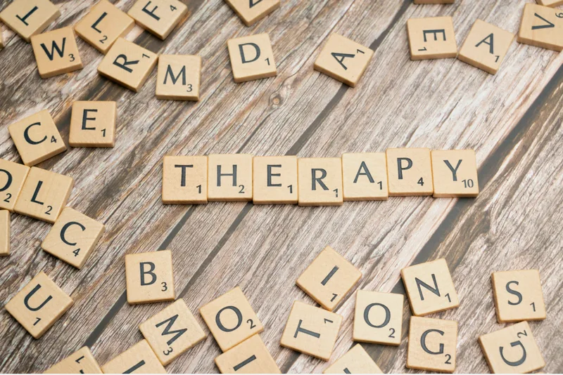 Wooden letter tiles spelling Therapy on a table